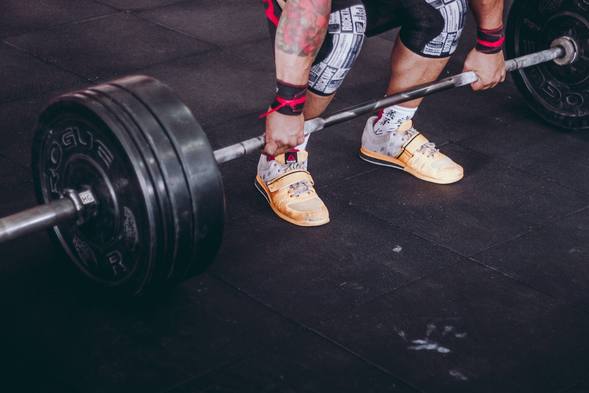 person lifting black and gray metal barbell